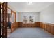 A versatile living space features wood paneling, neutral carpet, and natural light at 7746 S Harrison Cir, Centennial, CO 80122
