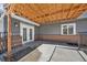 Covered back patio with brick accents, gray siding, and access to the backyard at 7746 S Harrison Cir, Centennial, CO 80122