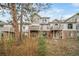 Multi-level townhome featuring stone accents and private balconies nestled among mature trees at 5395 Canyon View Dr, Castle Rock, CO 80104