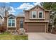 Two-story home featuring brick and wood siding, a two car garage, and a well-manicured lawn at 5307 E Courtney Ave, Castle Rock, CO 80104