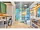 Bright bathroom featuring a glass-enclosed shower, sleek fixtures, and a laundry area at 3270 S Galapago St, Englewood, CO 80110