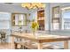 Sunlit dining room featuring a rustic wooden table and benches, with built-in shelving at 3270 S Galapago St, Englewood, CO 80110