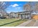 Cozy home with inviting front porch featuring a swing and well-manicured lawn at 3270 S Galapago St, Englewood, CO 80110