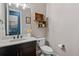 Elegant half bathroom with dark wood vanity, white countertop, and decorative wall shelving at 9563 Red Primrose St, Franktown, CO 80116