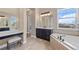 Elegant bathroom featuring soaking tub, makeup vanity and a large window at 9563 Red Primrose St, Franktown, CO 80116