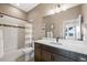 Bright bathroom featuring tile flooring, shower-tub combo, and a dark wood vanity with a white countertop and basin sink at 9563 Red Primrose St, Franktown, CO 80116