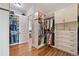 Spacious walk-in closet with custom shelving, rods, drawers, and wood flooring at 9563 Red Primrose St, Franktown, CO 80116