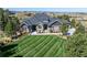 Beautiful home featuring a manicured lawn, stone accents, and a welcoming front porch with chairs at 9563 Red Primrose St, Franktown, CO 80116