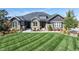 Charming home featuring manicured lawn, stone accents, and cozy seating area on the front porch at 9563 Red Primrose St, Franktown, CO 80116