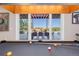 Game room with pool table and sliding glass doors leading to an outdoor patio with a large dining table and seating area at 9563 Red Primrose St, Franktown, CO 80116