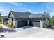 Exterior angle showcasing a spacious three car garage with a wide driveway and partial stone accents at 9563 Red Primrose St, Franktown, CO 80116