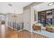 Upstairs landing with iron railing leading to an office nook with custom bookshelves and cozy seating area at 9563 Red Primrose St, Franktown, CO 80116
