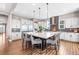 Spacious kitchen features a huge island with seating for eight, white cabinets, and stainless appliances at 9563 Red Primrose St, Franktown, CO 80116