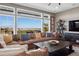 Inviting living room with a comfortable sectional sofa and expansive windows offering stunning panoramic views of the landscape at 9563 Red Primrose St, Franktown, CO 80116