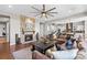 Living room with a stone fireplace, a large ceiling fan and an open view to the kitchen at 9563 Red Primrose St, Franktown, CO 80116