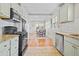 Bright open kitchen flows into the dining area with wood floors and natural light at 826 Madison St, Denver, CO 80206