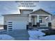 Charming single-story home featuring stone accents, a front porch, and a modern garage door with glass panels at 42976 Colonial Trl, Elizabeth, CO 80107