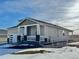 Attractive single-story home with a covered porch and neutral siding, complemented by snowy landscaping at 42976 Colonial Trl, Elizabeth, CO 80107