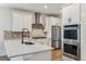 Modern kitchen with white cabinets, stainless steel appliances, and herringbone backsplash at 42976 Colonial Trl, Elizabeth, CO 80107