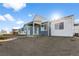 A view of the back of the home showing the gray siding, covered patio, and sliding glass doors at 761 Muturu Rd, Johnstown, CO 80542