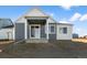 Home's backyard patio with gray siding, a covered patio, and sliding glass doors at 761 Muturu Rd, Johnstown, CO 80542