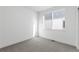 Bright bedroom features a large window providing natural light, complemented by neutral wall paint and plush gray carpet at 761 Muturu Rd, Johnstown, CO 80542