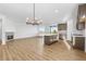 A spacious living room and kitchen area with modern light fixtures and a cozy fireplace at 761 Muturu Rd, Johnstown, CO 80542