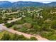 Overhead view capturing the neighborhood surrounded by lush greenery, rolling hills, and distant mountain views on a clear sunny day at 776 Hilltop Rd, Palmer Lake, CO 80133