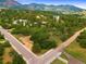 Overhead view showcasing the home nestled among lush green trees, roads, and nearby mountain scenery, offering privacy and tranquility at 776 Hilltop Rd, Palmer Lake, CO 80133