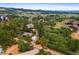 Bird's eye view showing a home, garage, and driveway surrounded by lush green trees and natural landscaping in a peaceful setting at 776 Hilltop Rd, Palmer Lake, CO 80133