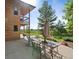 Inviting backyard patio with a glass top table, chairs, and an umbrella, ideal for outdoor dining and enjoying the peaceful scenery at 776 Hilltop Rd, Palmer Lake, CO 80133