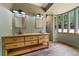 Beautiful bathroom with dual vanity, wooden accents, and bright windows for natural light at 776 Hilltop Rd, Palmer Lake, CO 80133