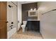 Updated bathroom with a white-tiled shower, dark vanity, and patterned floor tiles at 776 Hilltop Rd, Palmer Lake, CO 80133