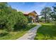 Stunning exterior of a home with a winding stone path leading to the front door, surrounded by lush greenery and mature trees at 776 Hilltop Rd, Palmer Lake, CO 80133
