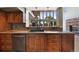 Warm kitchen with dark wood cabinets, stone counters and stainless steel dishwasher at 776 Hilltop Rd, Palmer Lake, CO 80133