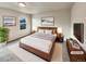 Virtually staged main bedroom with wood bed frame and large TV at 10968 Grange Creek Dr, Thornton, CO 80233