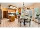 Open kitchen and dining area boasts wood cabinets, tile floors, and a chandelier-lit dining table at 16519 E Hialeah Dr, Centennial, CO 80015