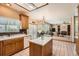 Bright kitchen with island, skylight, wood cabinets, and view to Gathering room at 16519 E Hialeah Dr, Centennial, CO 80015