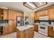 Traditional kitchen features wood cabinets, tiled floor, island, and stainless steel appliances at 16519 E Hialeah Dr, Centennial, CO 80015