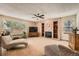 Spacious living room features a brick fireplace, built-in shelves, large windows, and ceiling fan at 16519 E Hialeah Dr, Centennial, CO 80015