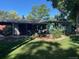 View of the backyard featuring a lawn, patio, and the rear of the house, surrounded by mature trees at 6930 S Delaware St, Littleton, CO 80120