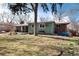 Lush backyard with a covered patio, seating, and mature trees, creating a serene outdoor living space at 6930 S Delaware St, Littleton, CO 80120