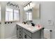 Updated bathroom with double sinks, gray vanity and drawers, accented by modern black hardware at 6930 S Delaware St, Littleton, CO 80120