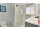 Bright bathroom featuring a glass enclosed shower and sleek gray vanity with black hardware at 6930 S Delaware St, Littleton, CO 80120