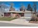 Charming brick home showcasing a well-kept lawn and a spacious driveway leading to the garage at 6930 S Delaware St, Littleton, CO 80120