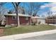 Single story brick house with well-maintained lawn, blue skies and leafless trees at 6930 S Delaware St, Littleton, CO 80120