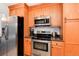 Bright kitchen with stainless steel oven, microwave, and fridge; featuring oak cabinets at 6930 S Delaware St, Littleton, CO 80120