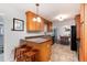A kitchen with breakfast bar, stainless steel appliances, tile floors, and bright lighting near the dining area at 6930 S Delaware St, Littleton, CO 80120