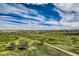Expansive aerial view of the community with manicured golf courses and vast blue skies at 7658 S Country Club Pkwy, Aurora, CO 80016