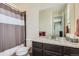 Updated bathroom featuring granite counters, decorative mirror, shower, and wood tile accent wall at 7658 S Country Club Pkwy, Aurora, CO 80016